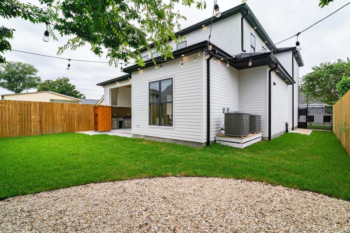 A modern two-story home with white James Hardie fiber cement lap siding and dark trim, viewed from the back yard.