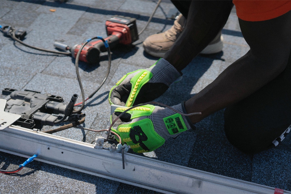 A Storm Roofing crew member working hands-on on a shingled residential roof.